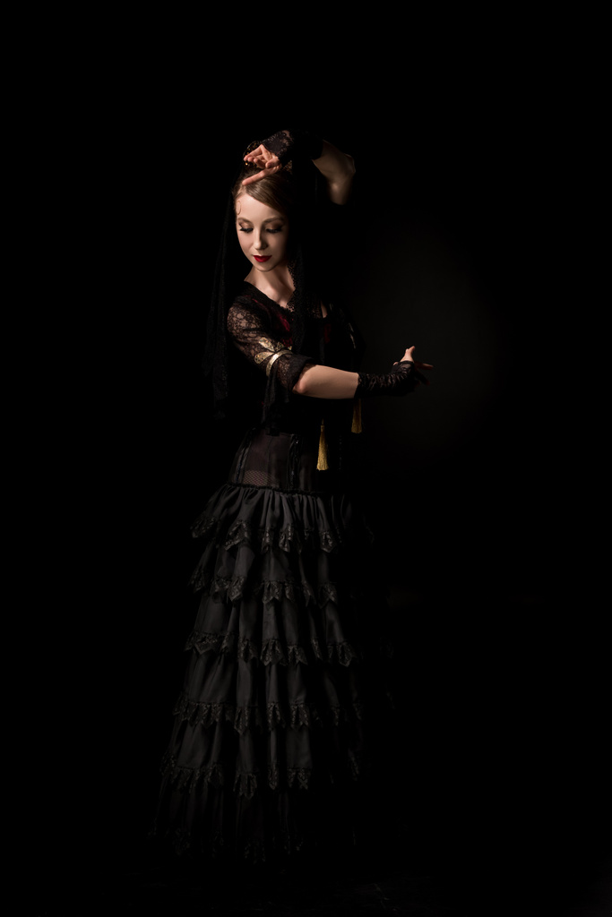 mooie jonge flamenco danser dansen in jurk geïsoleerd op zwart  - Foto, afbeelding