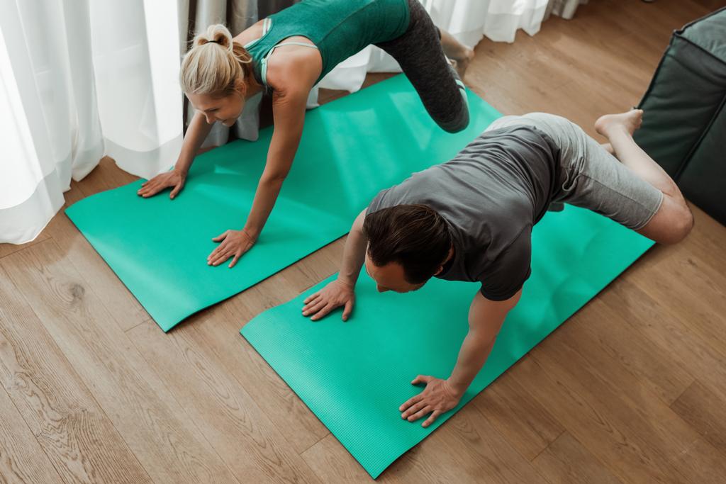 Visão geral do treinamento de casal maduro em tapetes de fitness juntos
  - Foto, Imagem