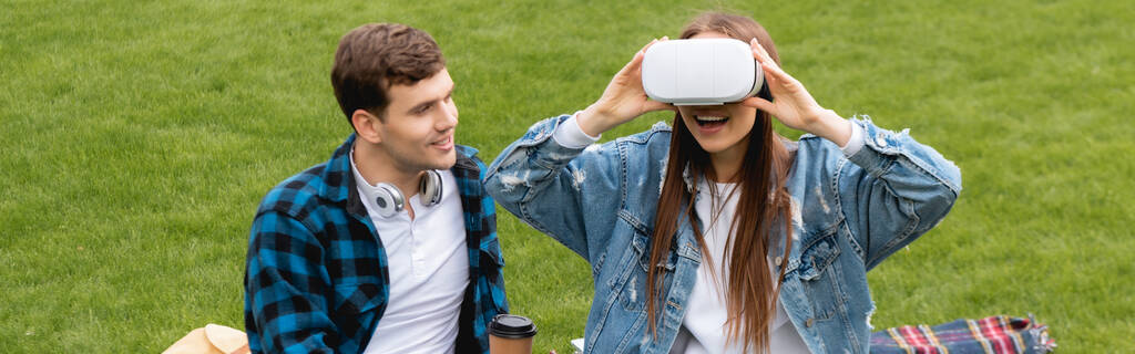 website header van vrolijke student kijken naar opgewonden meisje in virtual reality headset  - Foto, afbeelding