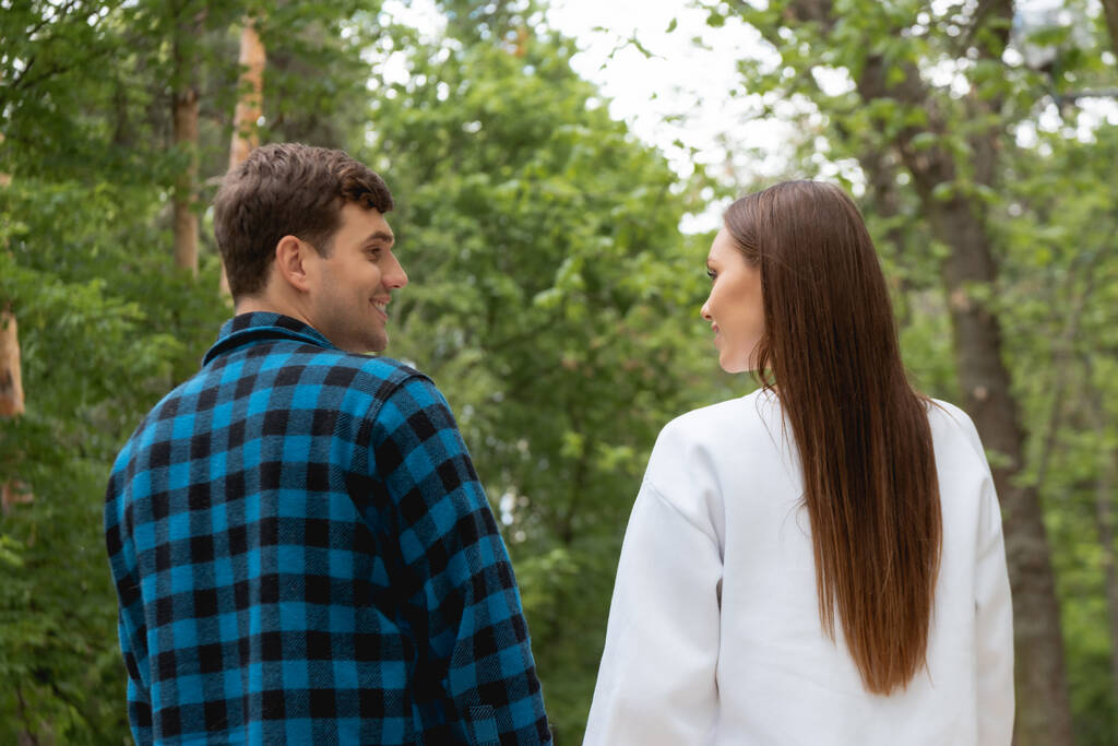 handsome boyfriend and girlfriend looking at each other in park  - Photo, Image