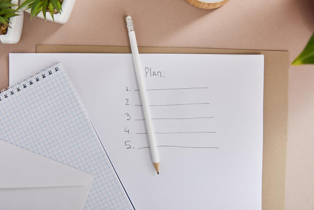 vista superior de plantas verdes, envelope, caderno em branco, lápis e papel com letras plano na superfície bege
 - Foto, Imagem