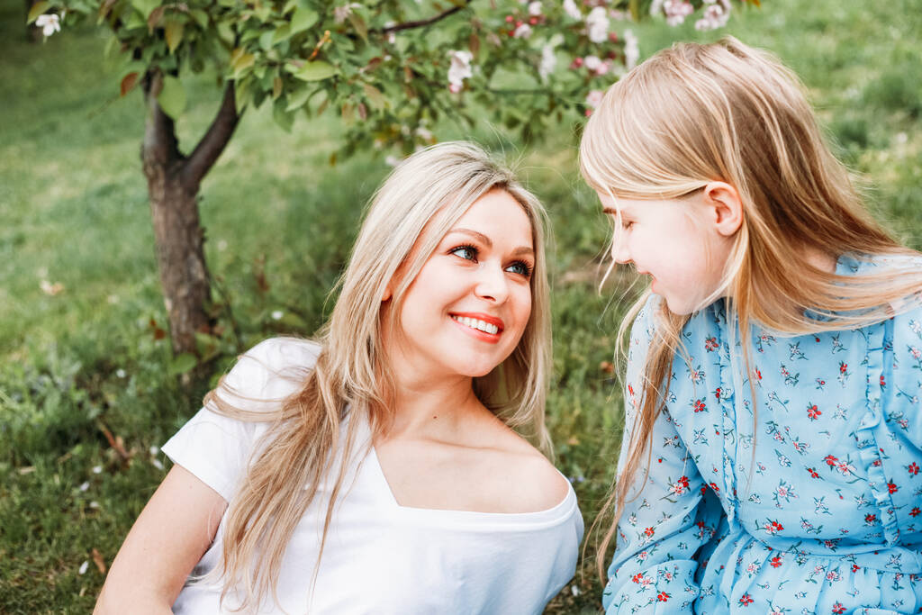 Girl, daughter with mother, blooming Apple trees, trees, flowers, branches, spring, summer, beauty, nature, communication, family, kiss, meeting - Photo, Image