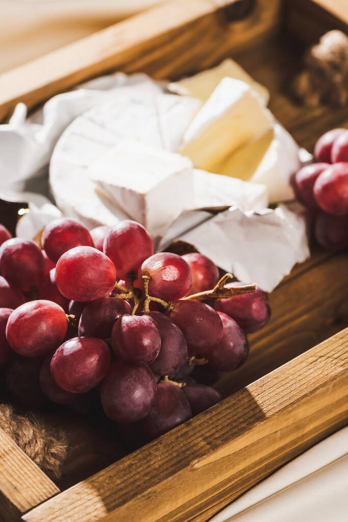 close up view of french breakfast with Camembert and grape on wooden tray - Photo, Image