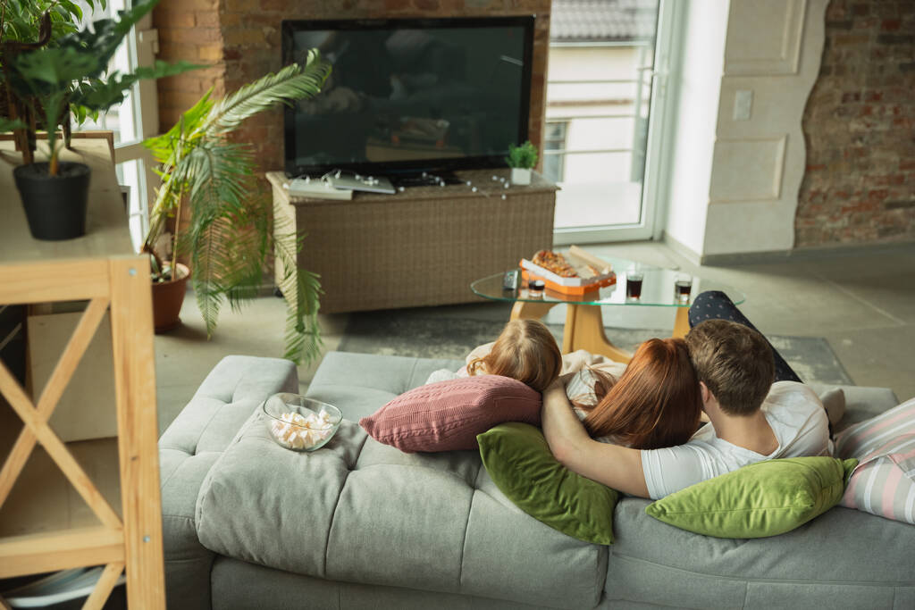Familia pasar un buen tiempo juntos en casa, se ve feliz y alegre, viendo la televisión
 - Foto, Imagen