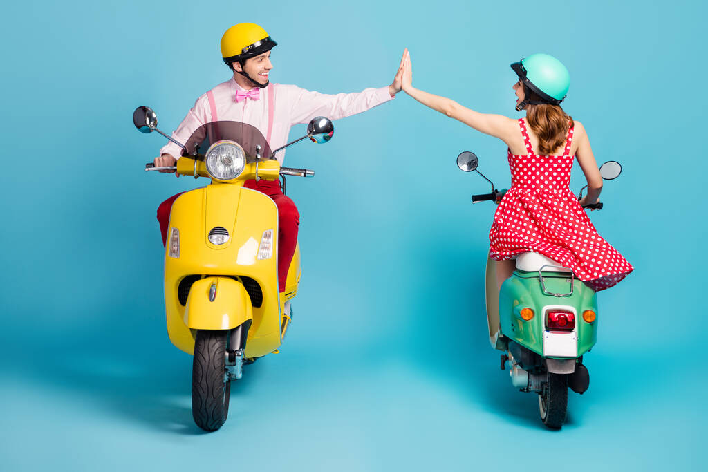 Teljes hosszúságú fotó pozitív két ember férfi nő lovaglás motorkerékpár élvezze a gyors sebesség verseny siker csapat munka tartsa a kezét magas öt kopás formalwear ruhát elszigetelt felett kék színű háttér - Fotó, kép