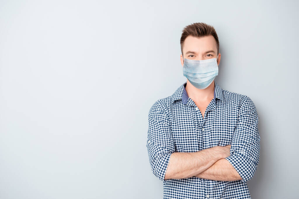 Портрет уверенного бородатого бизнесмена со скрещенными руками носит медицинскую маску безопасности на лице, концепцию защиты от пандемического коронного вируса
 - Фото, изображение
