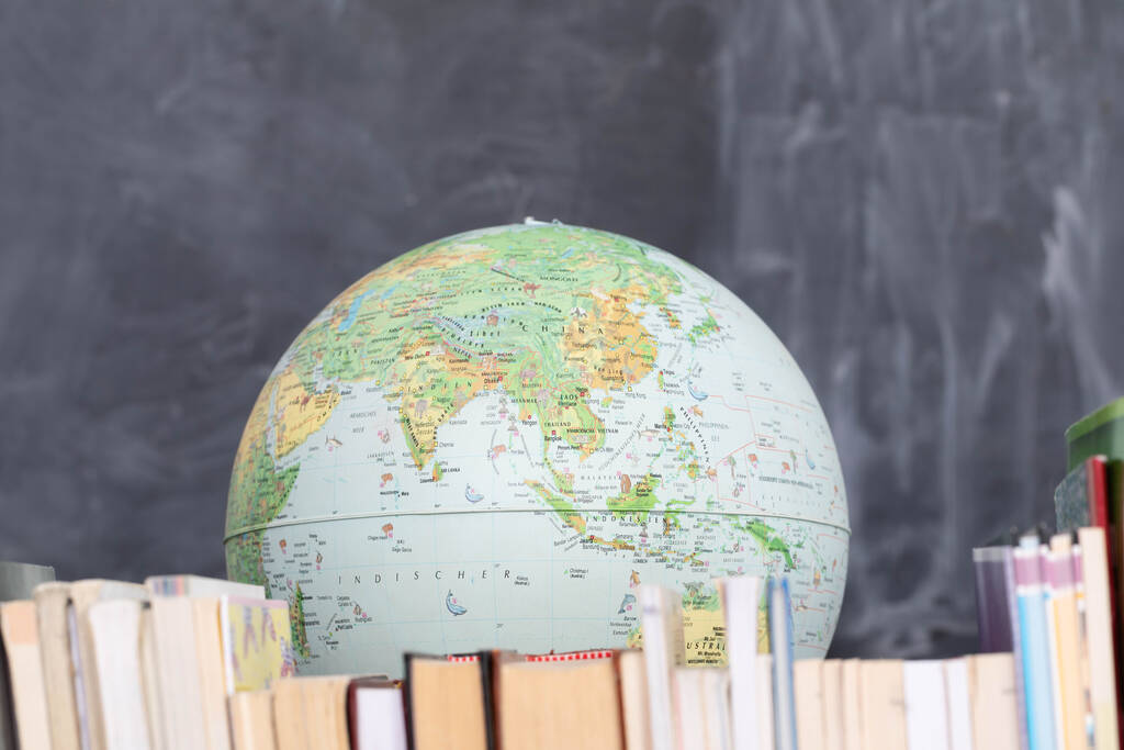 Geography lesson. A globe among a large number of school books. - Photo, Image