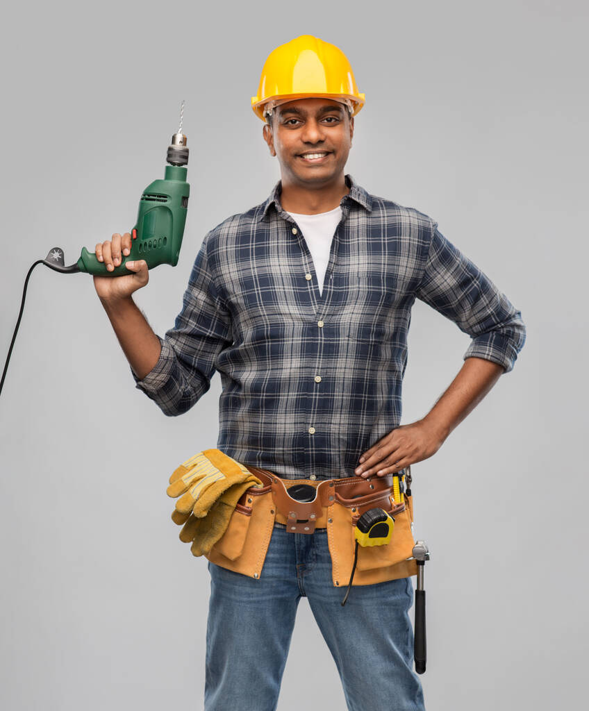 šťastný indický stavitel v helmě s elektrickým vrtákem - Fotografie, Obrázek