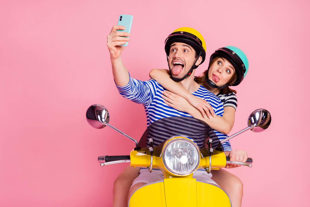 Ritratto del suo lui lei bella attraente allegro allegro allegro infantile comico giocoso coppia guida ciclomotore prendendo fare selfie divertirsi ingannando smorfia isolato su rosa pastello colore sfondo
 - Foto, immagini