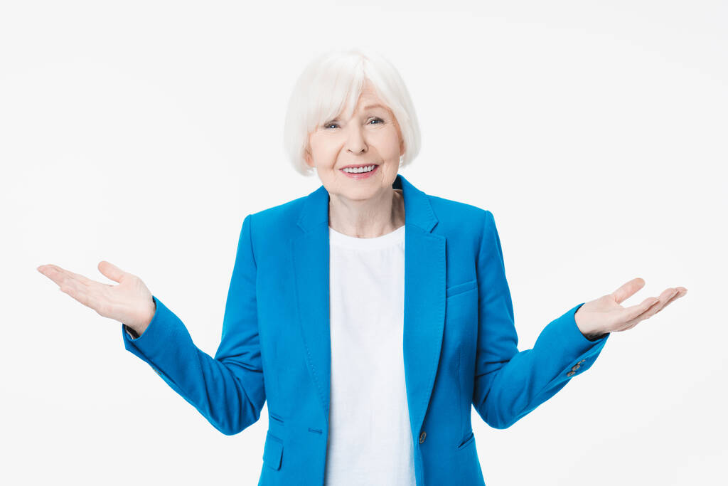 Mulher idosa encolhendo os ombros com expressão sem noção enquanto estava de pé contra o fundo branco
 - Foto, Imagem