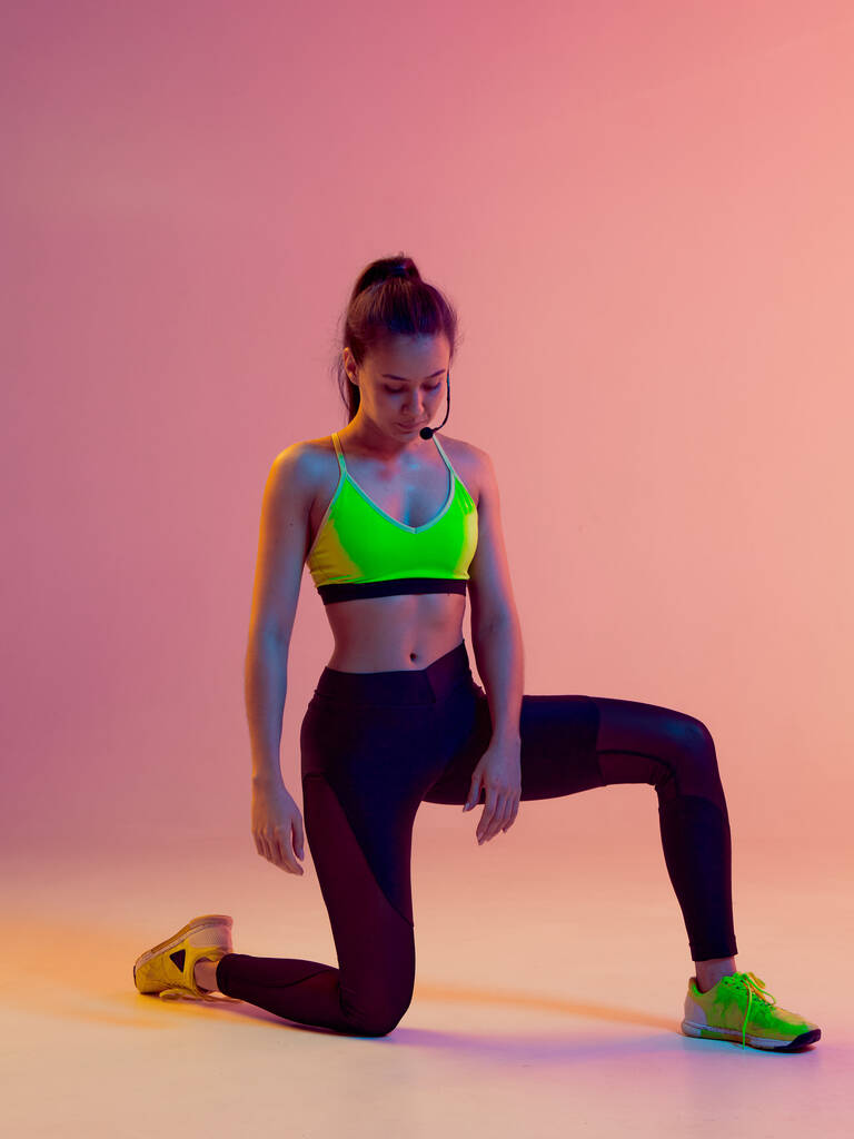 Молода спортивна дівчина-інструктор, яка викладає практику йоги своїм підопічним онлайн через відеоконференцію з мікрофоном
. - Фото, зображення