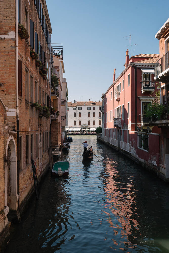 Wenecja, Włochy - 13 sierpnia 2016: Gondolier prowadzi gondolę po kanale w Wenecji, Włochy. - Zdjęcie, obraz