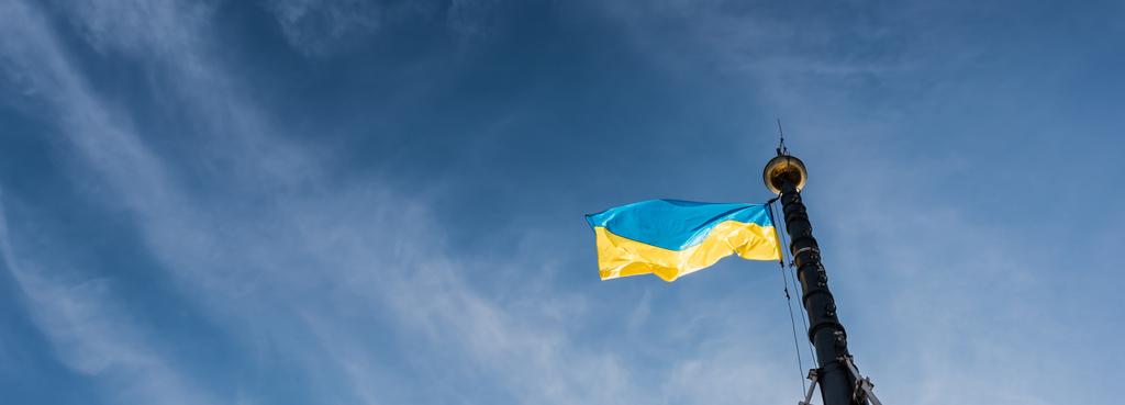image horizontale du drapeau ukrainien sur le mât de drapeau contre le ciel bleu à lviv, ukraine - Photo, image