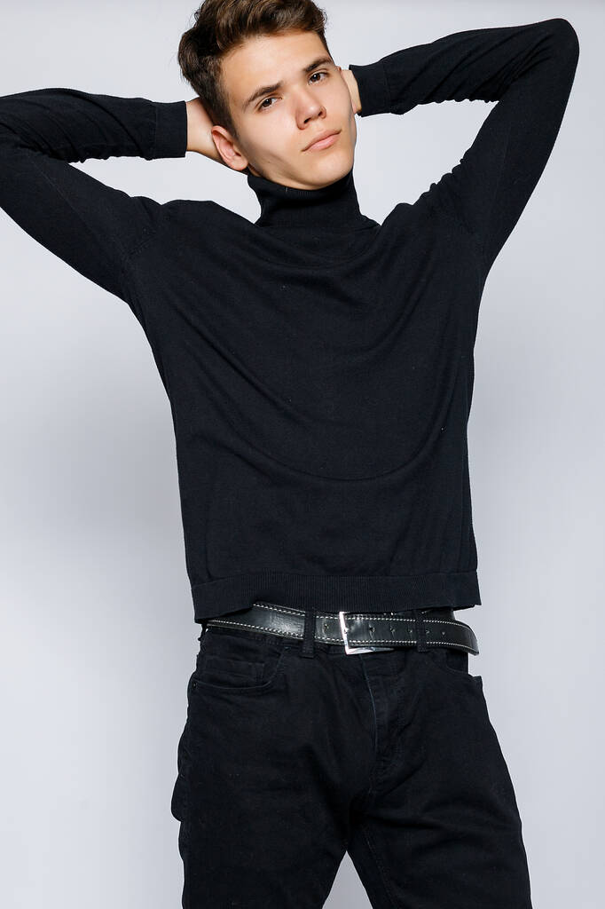 Молодой мускулистый мужчина в черной футболке и джинсах
 - Фото, изображение