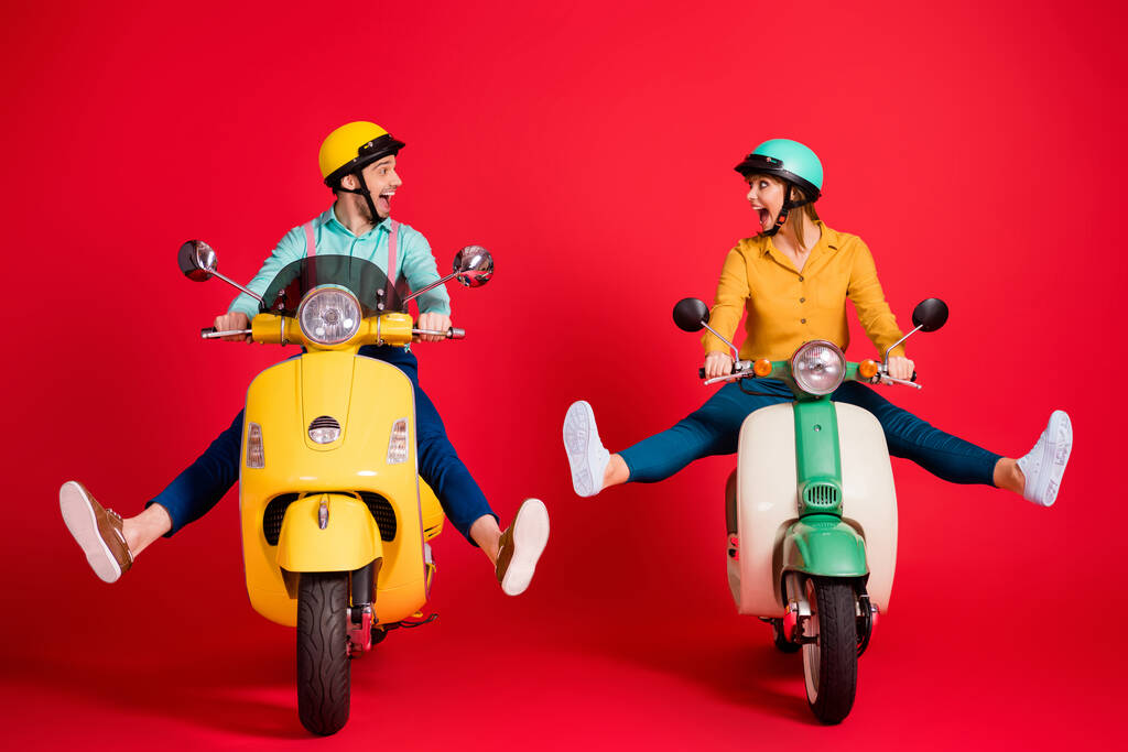 Portrét pěkné atraktivní funky bláznivý komický humorný nedbalý veselý veselý pár jízdy moped bez nohou baví izolované přes světlé živé lesk pulzující červené barvy pozadí - Fotografie, Obrázek