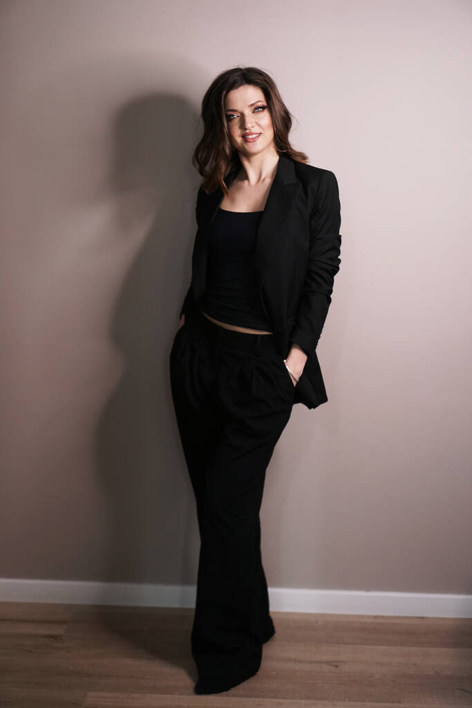 Fiduciosa donna d'affari in piedi a tutta lunghezza in abito nero
 - Foto, immagini