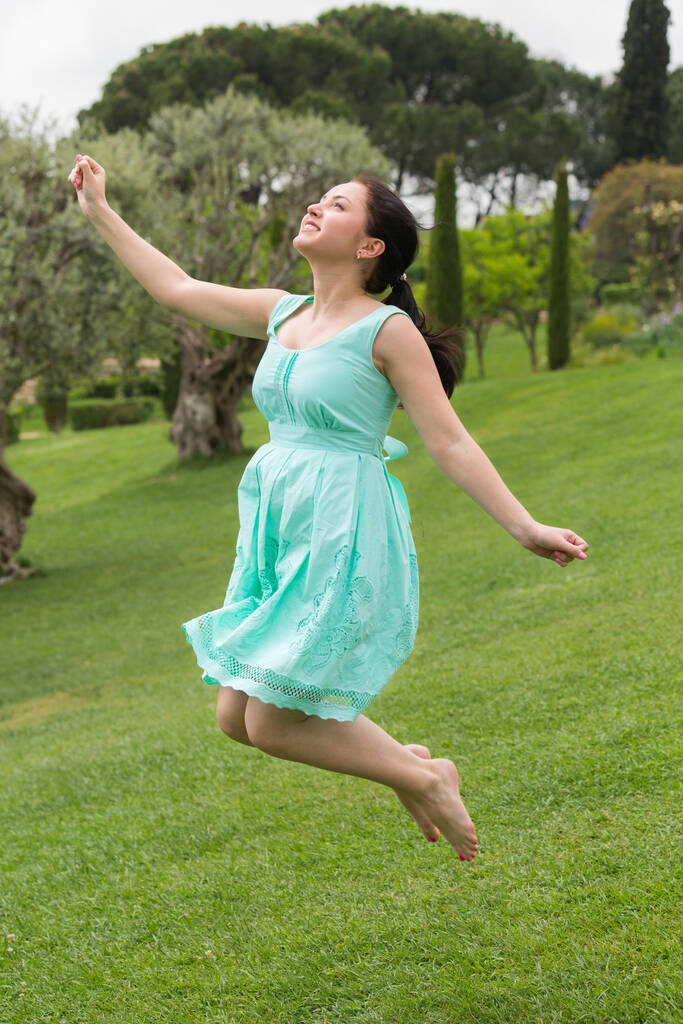 feliz joven morenita russiana vestida saltando en el parque. - Foto, Imagen
