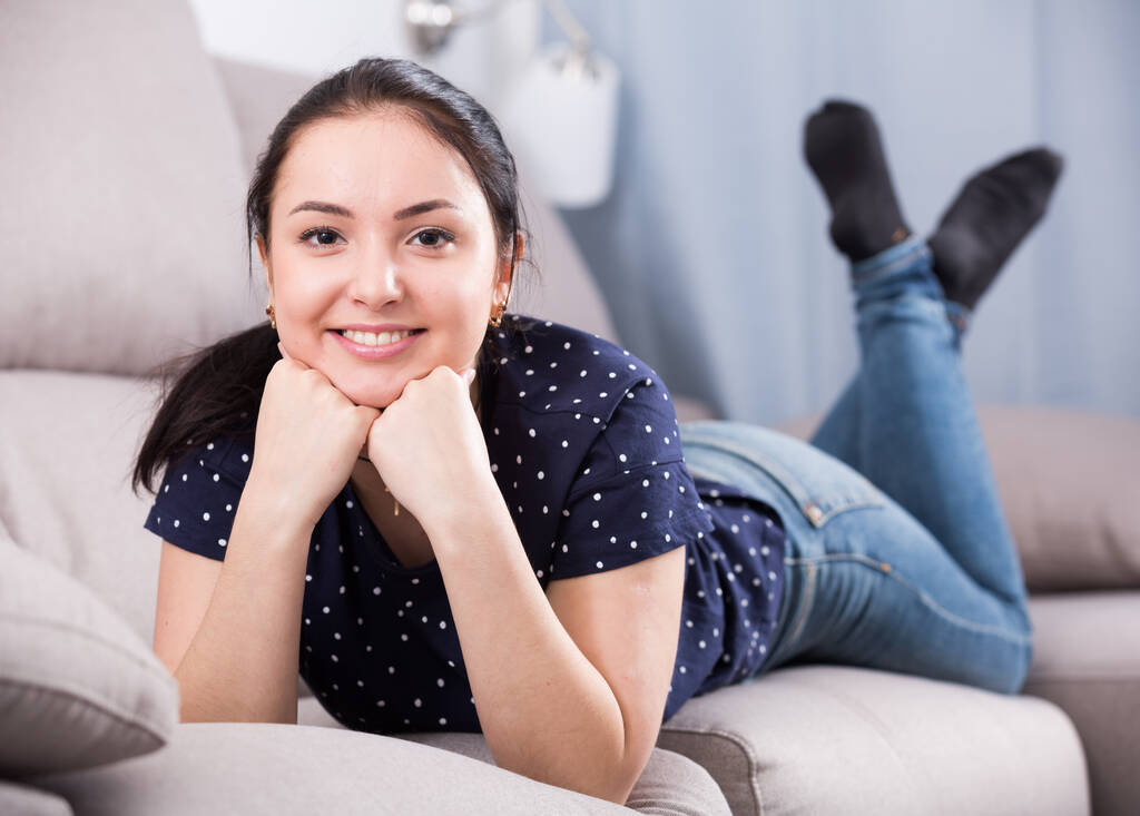 Pozitivní dívka oblečená tmavě modrá košile a džíny relaxační doma - Fotografie, Obrázek
