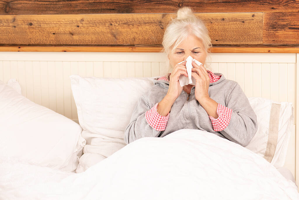 Хвора старша жінка лежить в ліжку вдома з нежить, відпочиває
. - Фото, зображення
