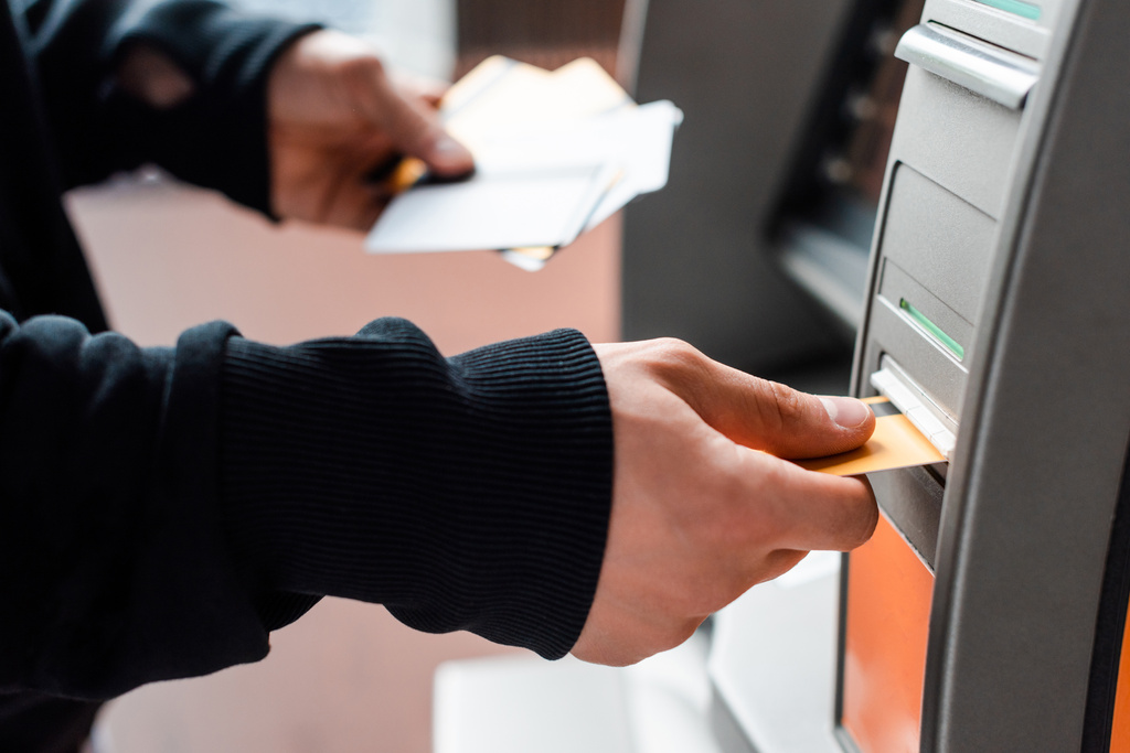 Automatizált pénztárgép használata közben hitelkártyát tartó tolvaj levágott nézete - Fotó, kép