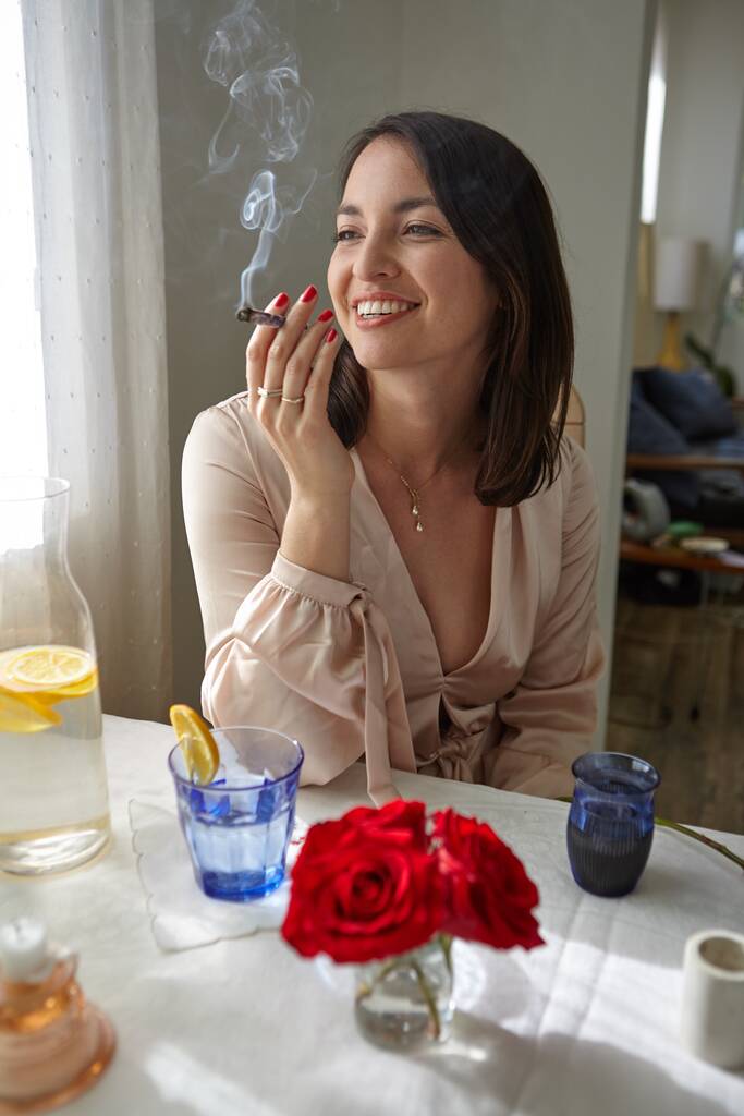 Mulher elegante fumar um charro em casa na mesa. - Foto, Imagem