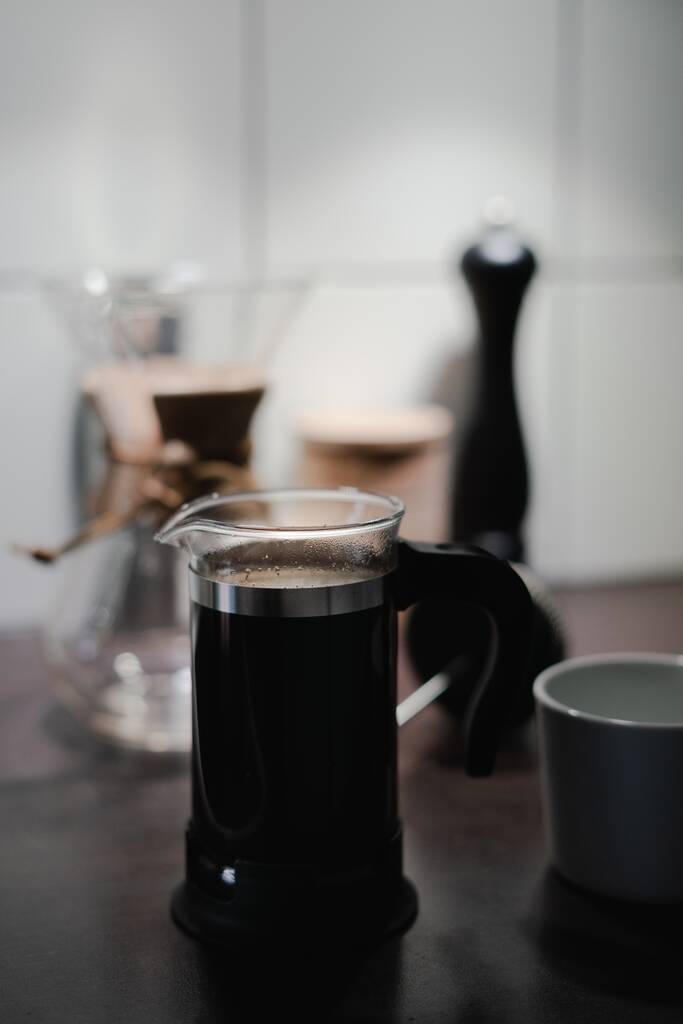 Een zachte focus van aromatische zwarte koffie in een koffiepers op een houten tafel - Foto, afbeelding