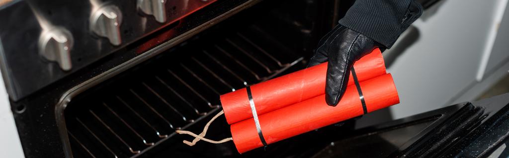 Panorâmica tiro de ladrão em luva de couro colocando dinamite no fogão na cozinha
  - Foto, Imagem