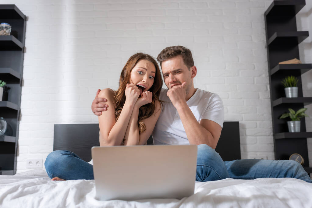 pareja emocional viendo película de miedo en el ordenador portátil en el dormitorio
  - Foto, imagen
