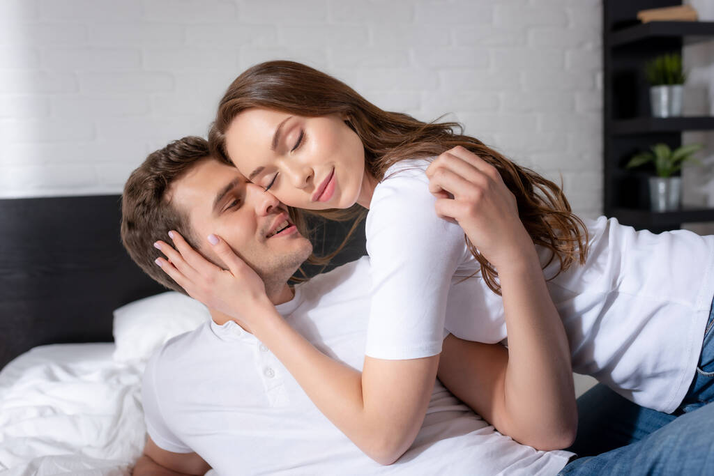 felice giovane donna con gli occhi chiusi abbracciare uomo felice in camera da letto
  - Foto, immagini