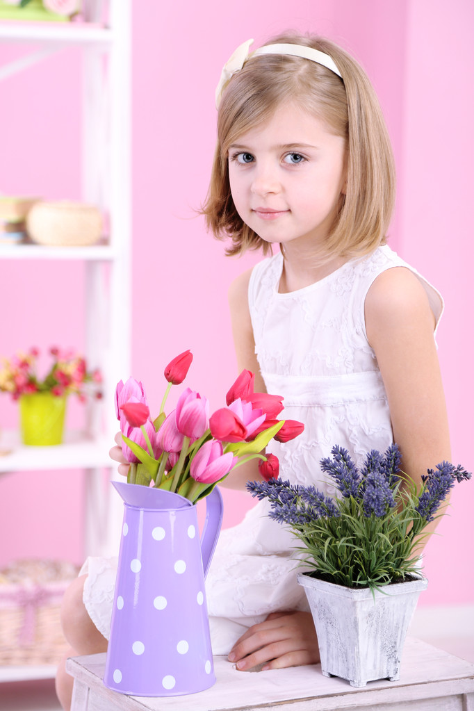 holčičky sedící na malé žebřík s květinami na růžovém pozadí - Fotografie, Obrázek