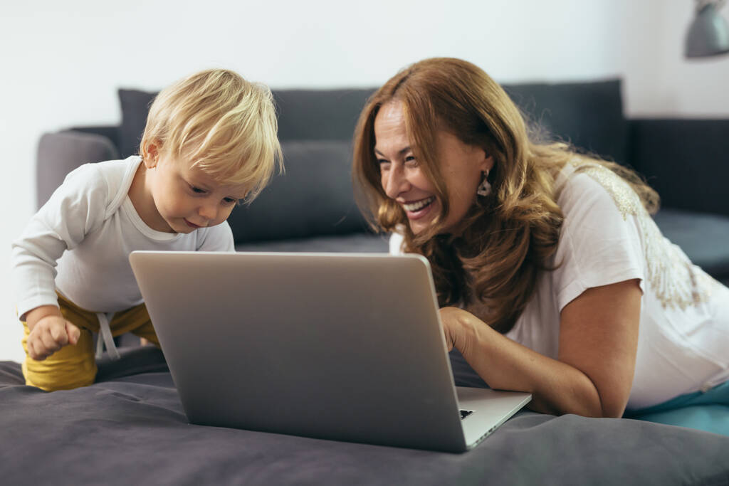 mulher madura com seu neto usando computador portátil em sua casa - Foto, Imagem