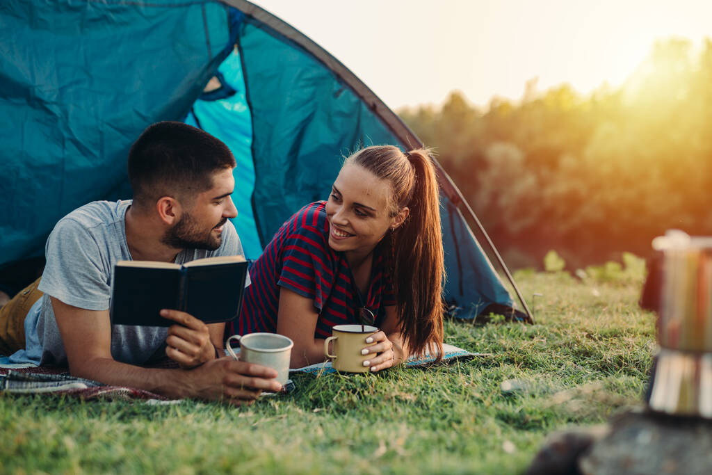 romantický pár na táboření ve stanu a čtení knihy - Fotografie, Obrázek