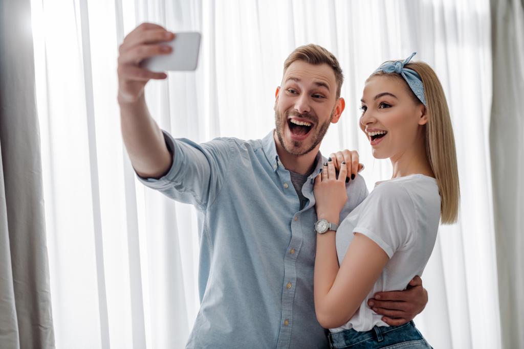 valikoiva painopiste innoissaan mies ottaen selfie kanssa iloinen tyttö  - Valokuva, kuva