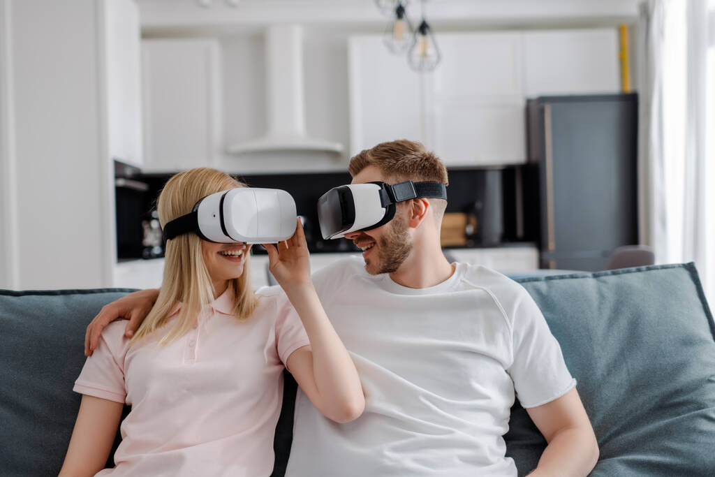 happy couple in virtual reality headsets gaming at home  - Photo, Image