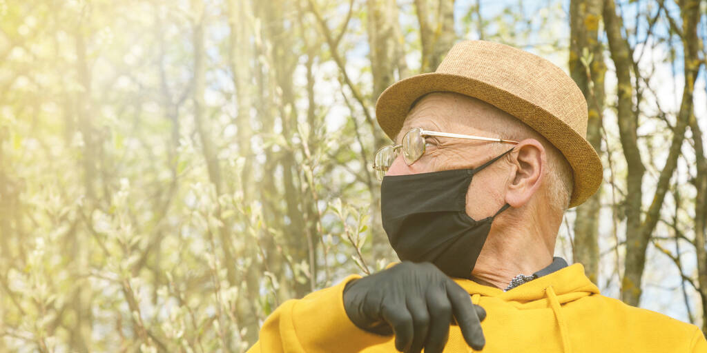 nyugdíjas szemüvegben és fekete maszkban a hátsó napfényben - Fotó, kép