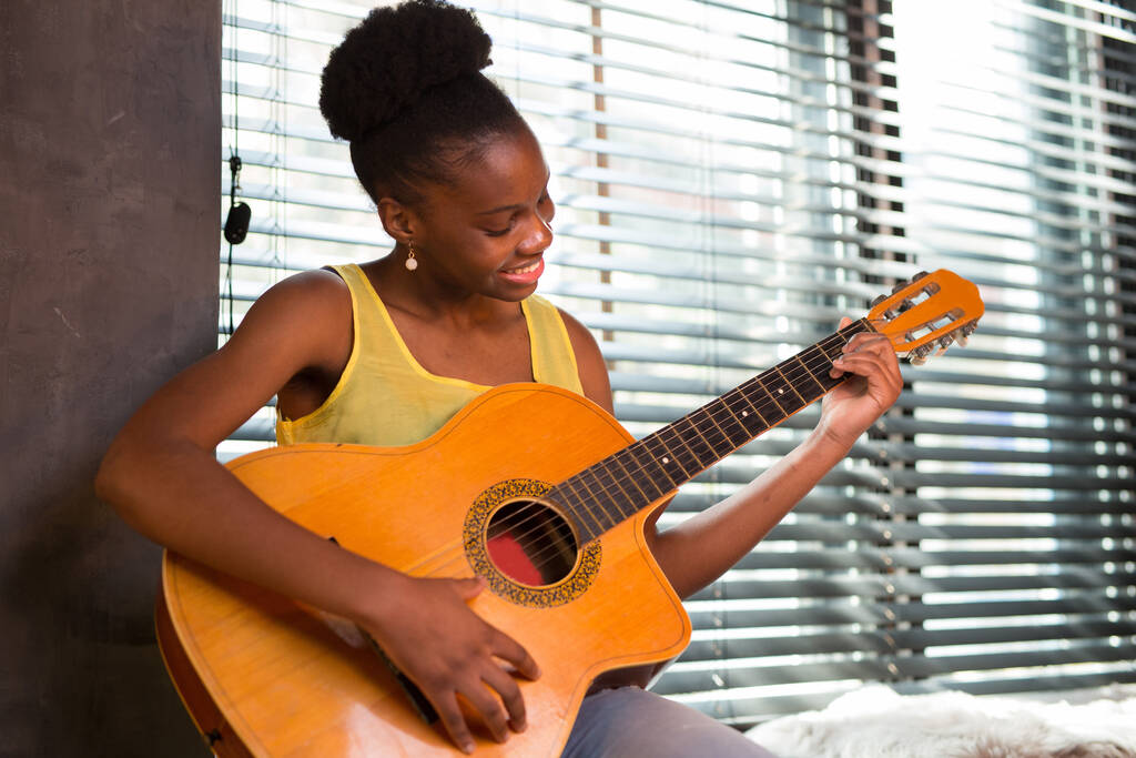 mooie jonge Afrikaanse vrouw spelen gitaar - Foto, afbeelding