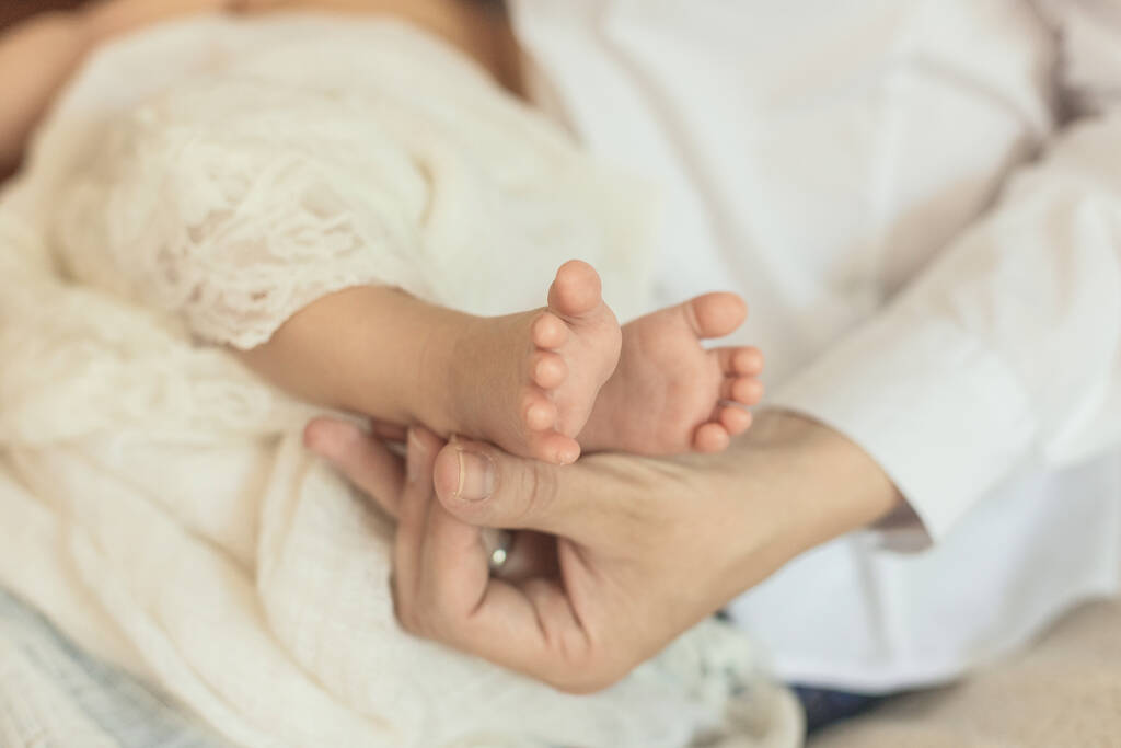 Каблуки новорожденного ребенка в руках мужчины
 - Фото, изображение