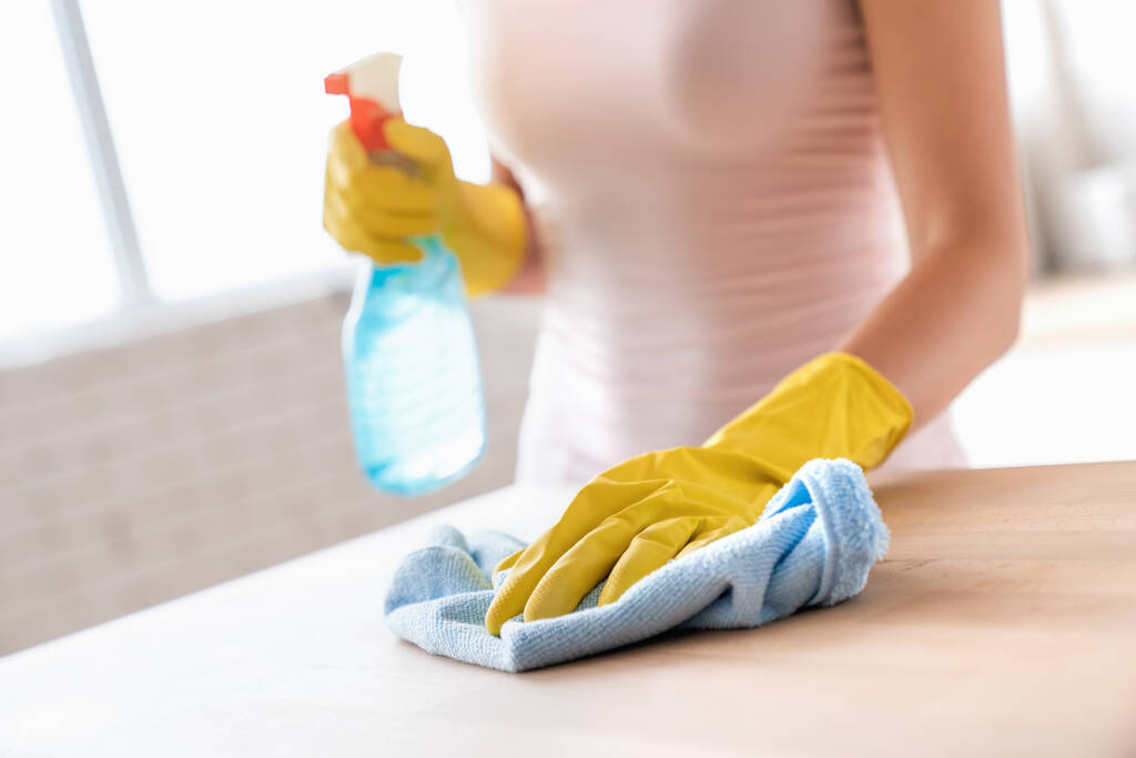 Close up of female housekeeper specialist hold blue duster cleaning table - Photo, Image