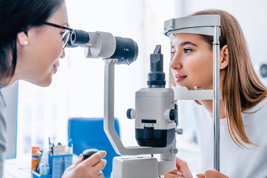 Foto vista lateral do médico e paciente na clínica de oftalmologia
 - Foto, Imagem