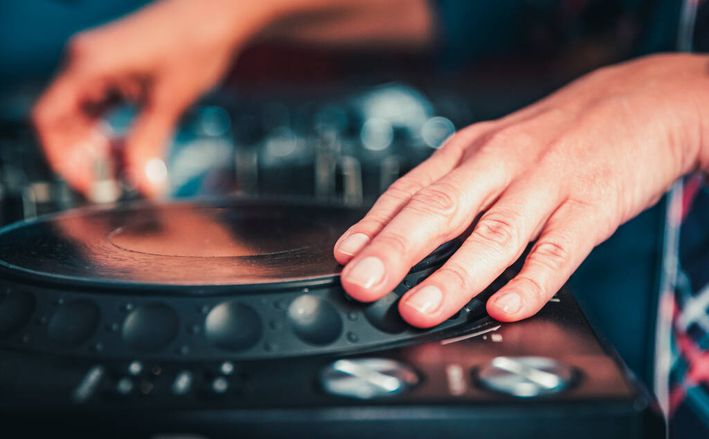 DJ Hands creëren en reguleren van muziek op dj console mixer in concert nachtclub podium. - Foto, afbeelding