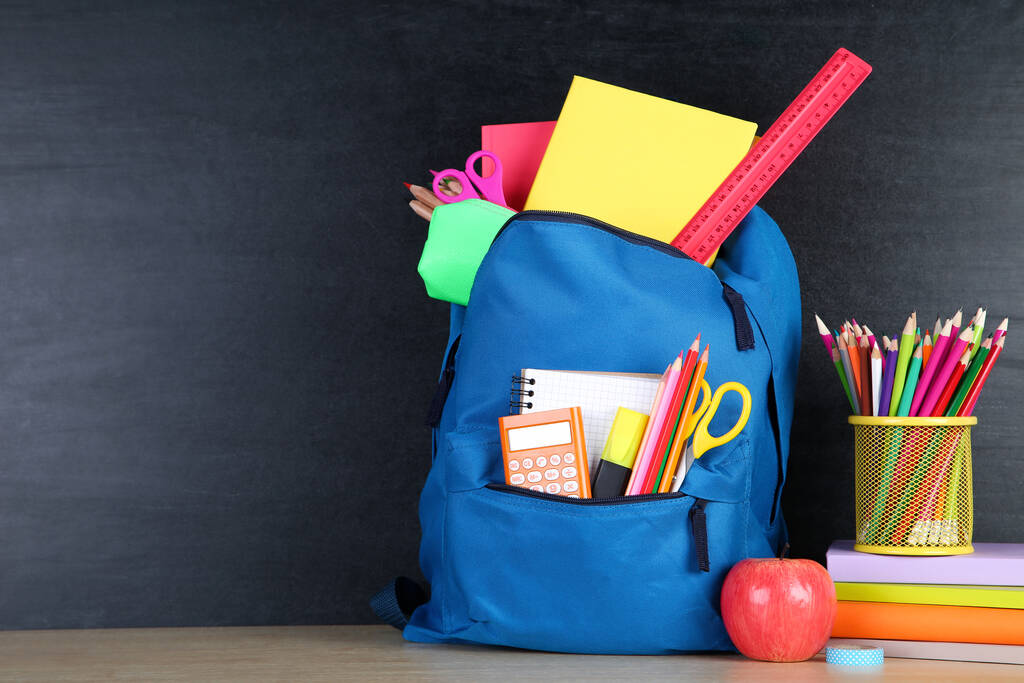 School supplies with blue backpack on blackboard background - Photo, Image