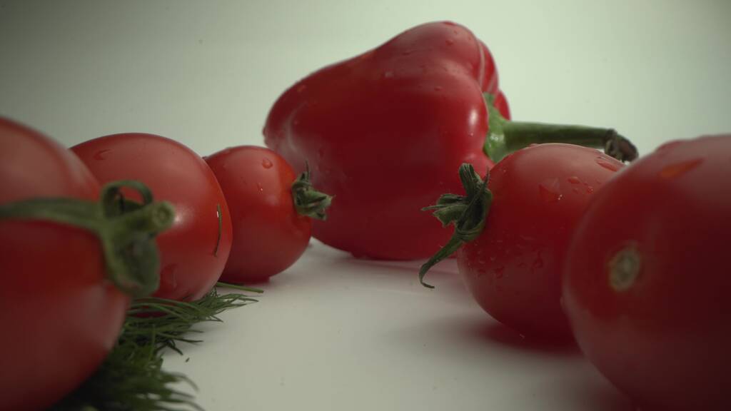 Φρεσκοκομμένα λαχανικά. Ντομάτες και πιπεριές σε λευκό τραπέζι. Θερινό φαγητό. Πριν το μαγείρεμα. Μακρό - Φωτογραφία, εικόνα