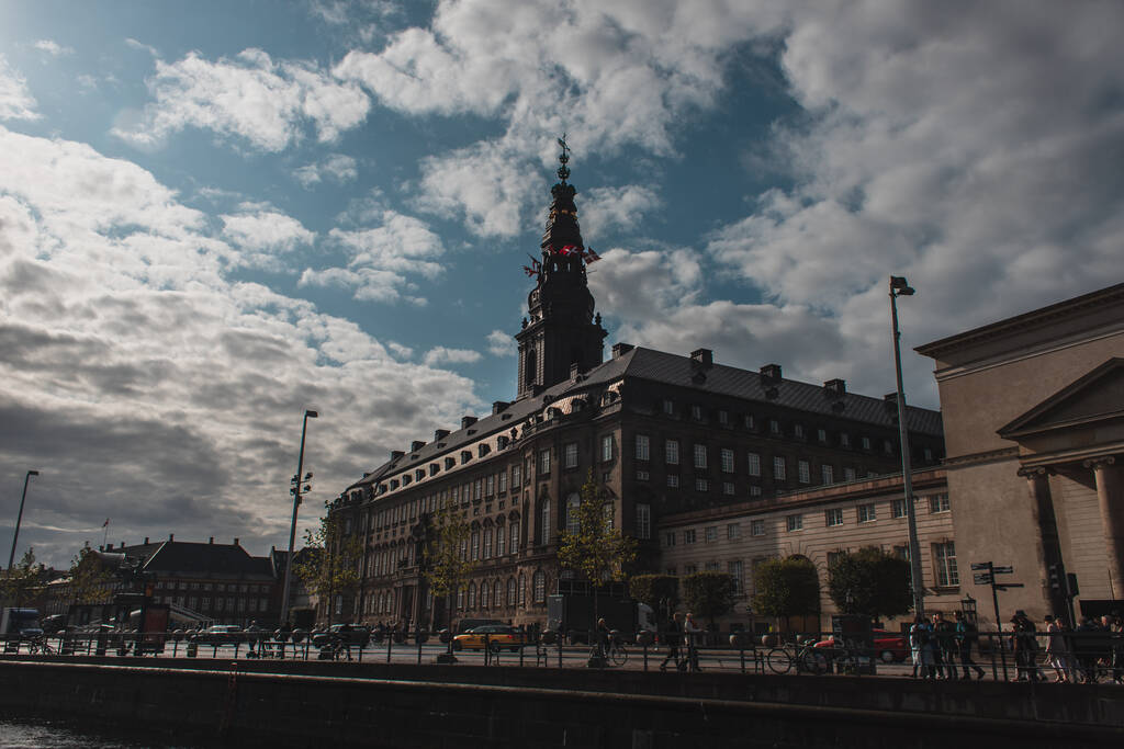 COPENHAGEN, DENEMARKEN - APRIL 30, 2020: Stedelijke straat met Christiansborg Palace toren en bewolkte lucht op de achtergrond  - Foto, afbeelding