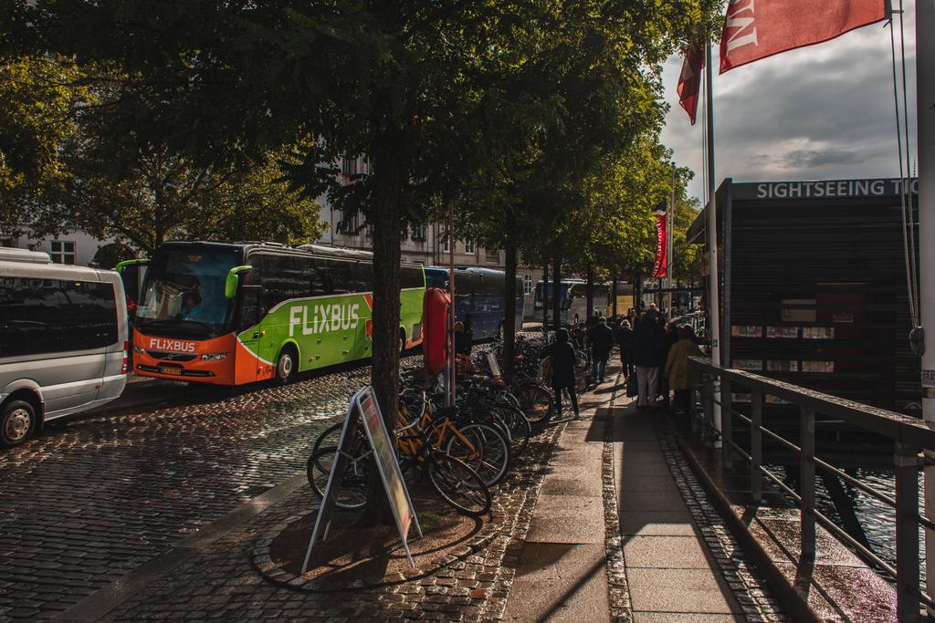 КОПЕНГАГЕН, ДЕНМАРК - 30 апреля 2020 года: Велосипеды возле деревьев и дороги на городской улице
  - Фото, изображение