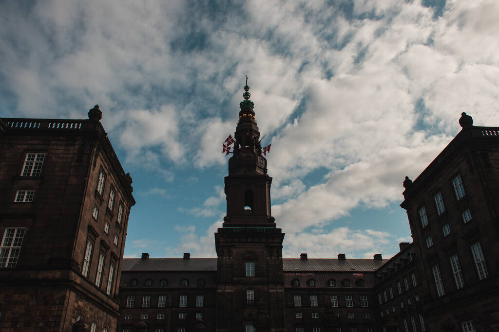 デンマークコペンハーゲンのクリスチャンボーグ宮殿のファサードのデンマークの旗の低角度ビュー  - 写真・画像