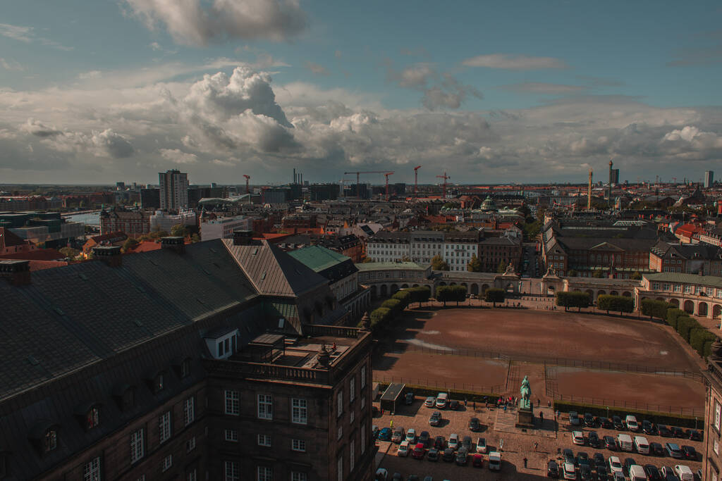 Vue en angle élevé du terrain et des voitures près de Christiansborg Palace avec ciel nuageux en arrière-plan à Copenhague, Danemark  - Photo, image