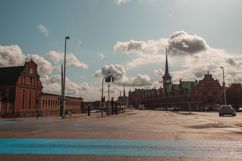 Calle urbana con fachada de edificio Borsen y cielo nublado al fondo en Copenhague, Dinamarca
  - Foto, Imagen