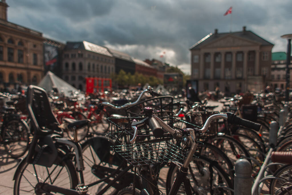 Danimarka 'nın Kopenhag kentsel caddesinde güneş ışığı alan bisikletlerin seçici odak noktası  - Fotoğraf, Görsel