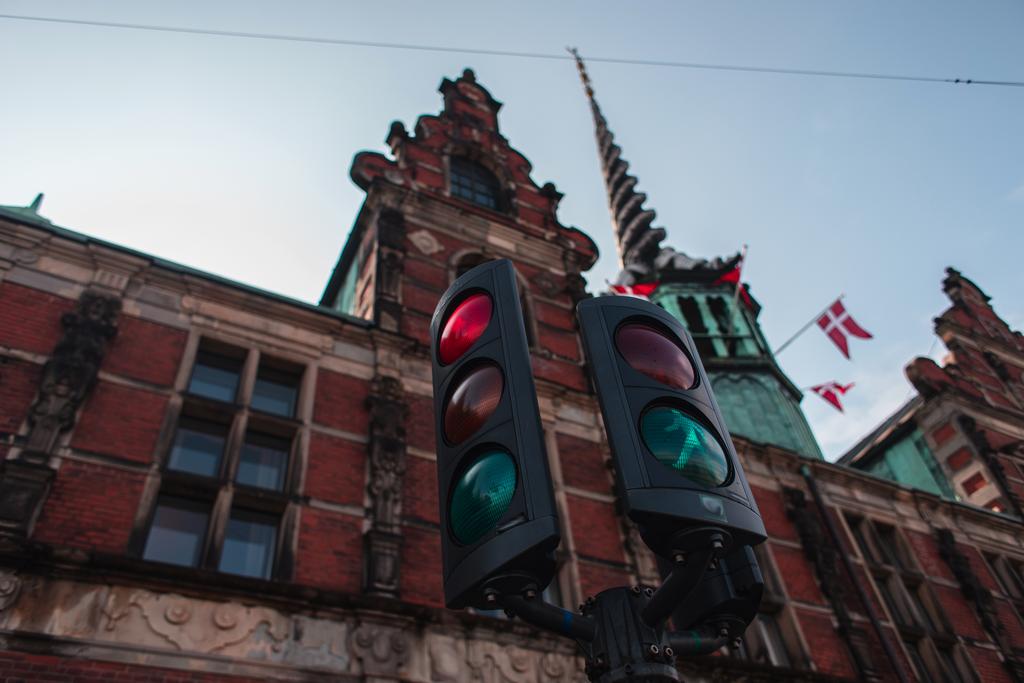 Selectieve focus van verkeerslichten met gevel van Borsen gebouw en blauwe lucht op de achtergrond in Kopenhagen, Denemarken  - Foto, afbeelding