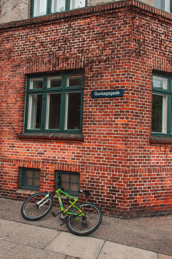 Bicicleta en la pasarela cerca de la fachada de ladrillo del edificio en Copenhague, Dinamarca
  - Foto, Imagen